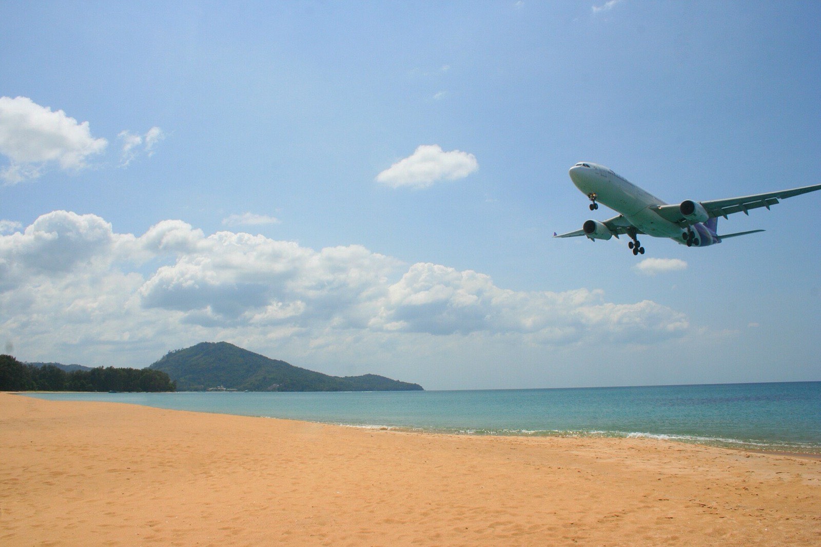 A Thai Airways aircraft on final approach over Mai Khao Beach, beside the runway at Phuket International Airport